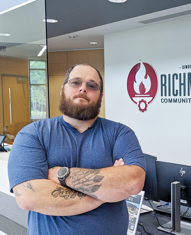 Jakob Lane stands with arms folded in the lobby of the Lee Building.
