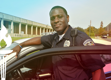 Rockingham Police Officer who graduated BLET from Richmond Community College stands beside his police car