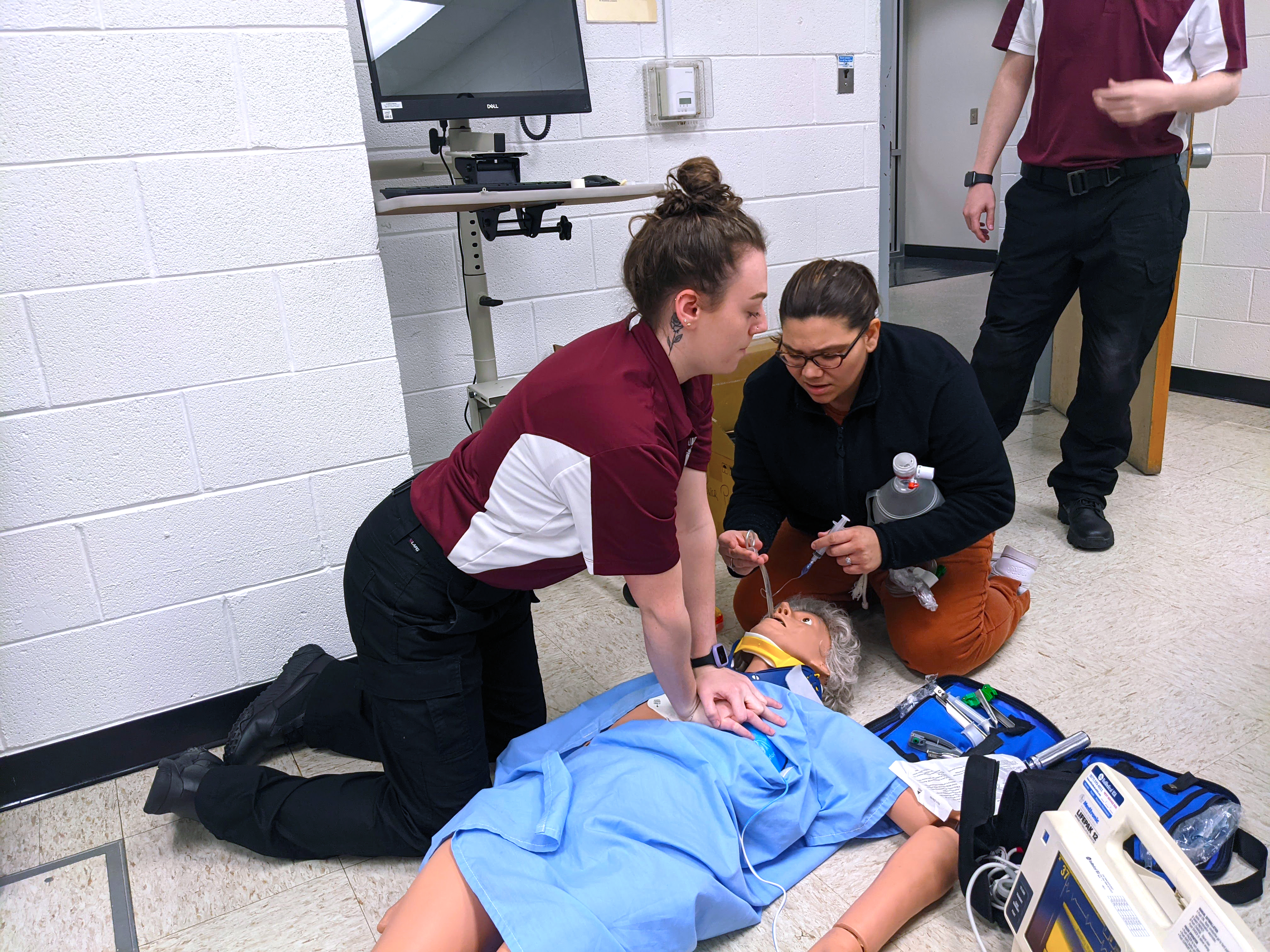 EMS students perform CPR on a mannequin