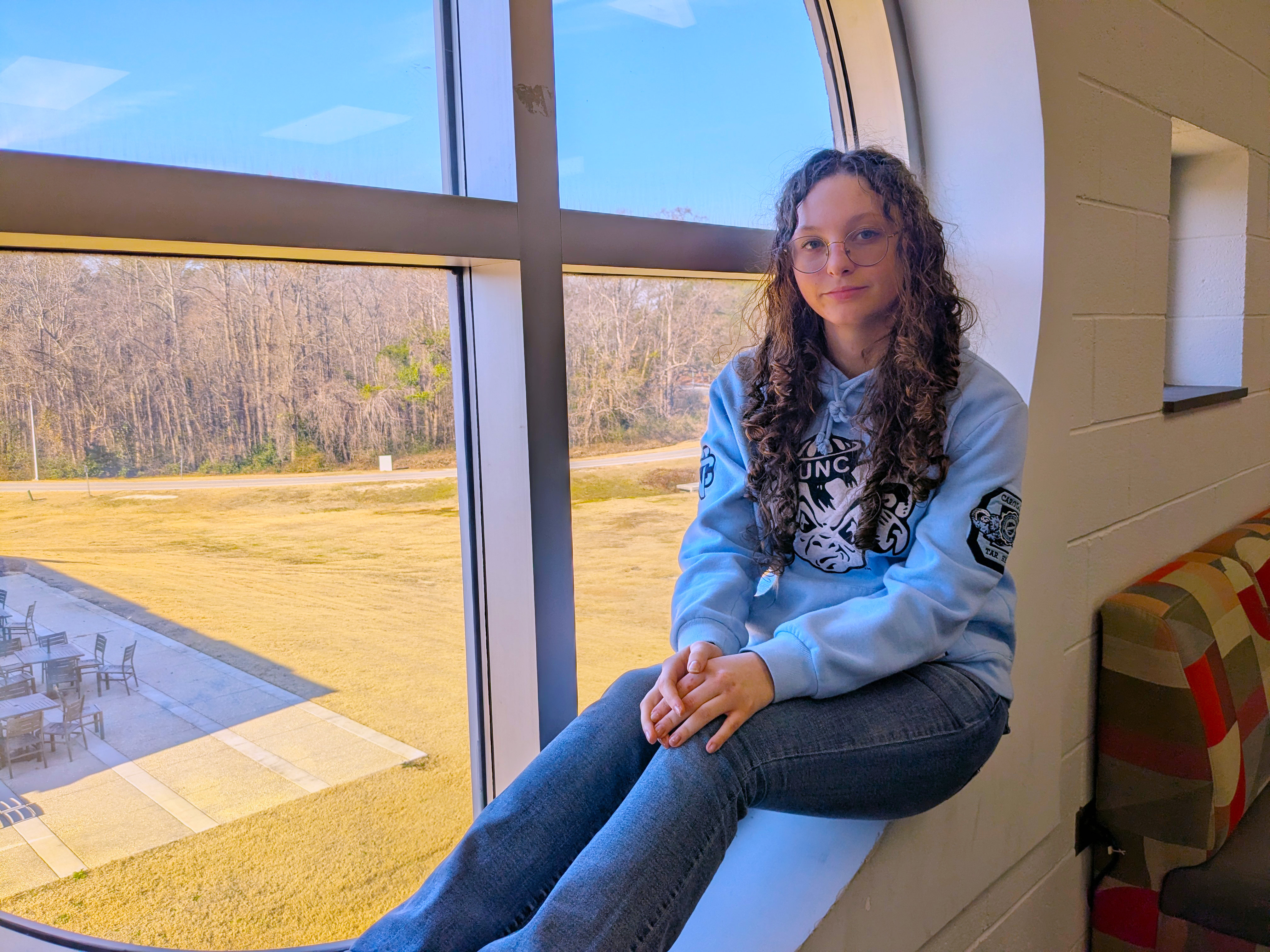 RichmondCC student Abigail Chavis sits on a window sill in the library.