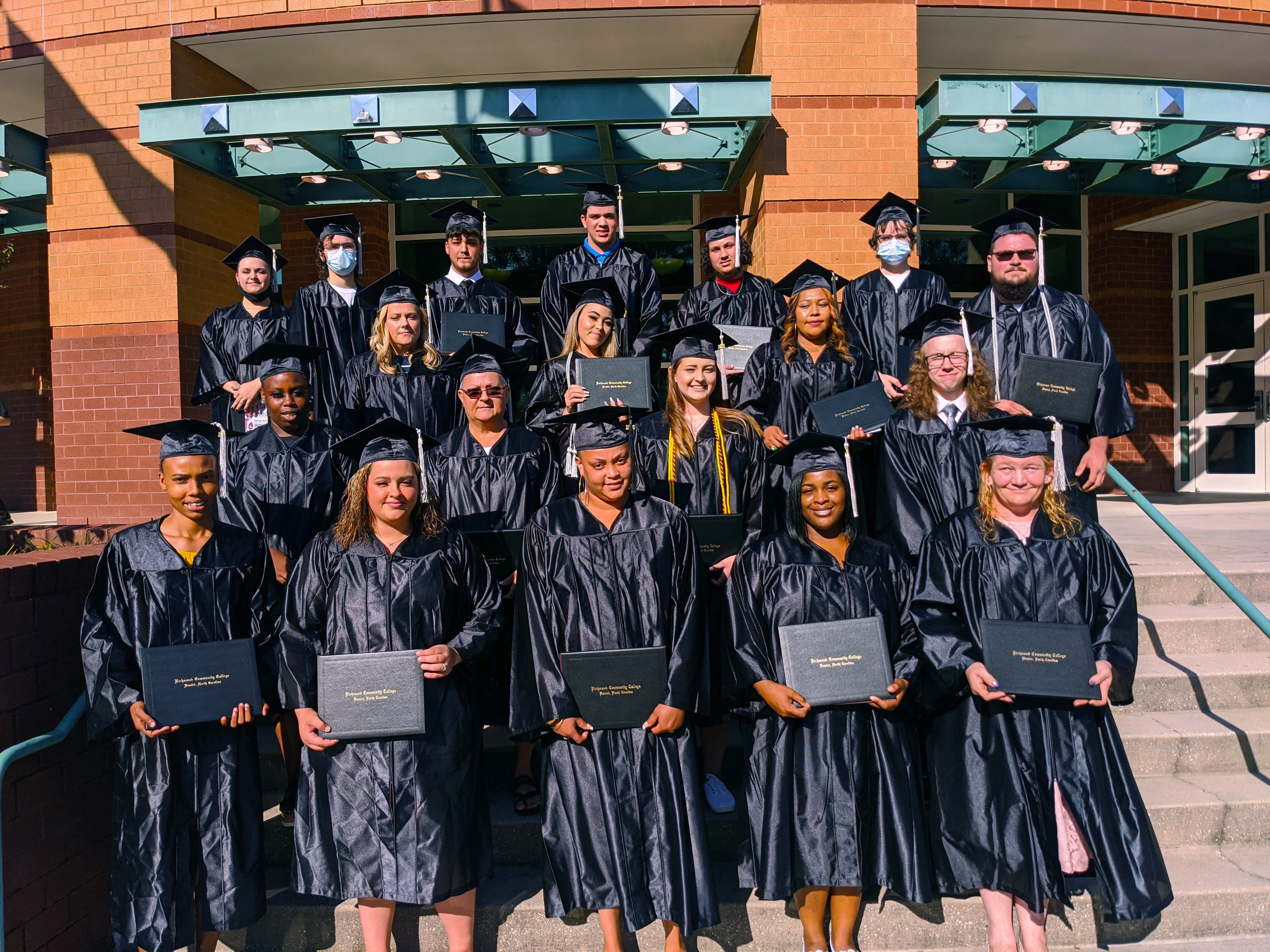 Adult High School/HSE graduates stand on the steps of the Cole Auditorium.