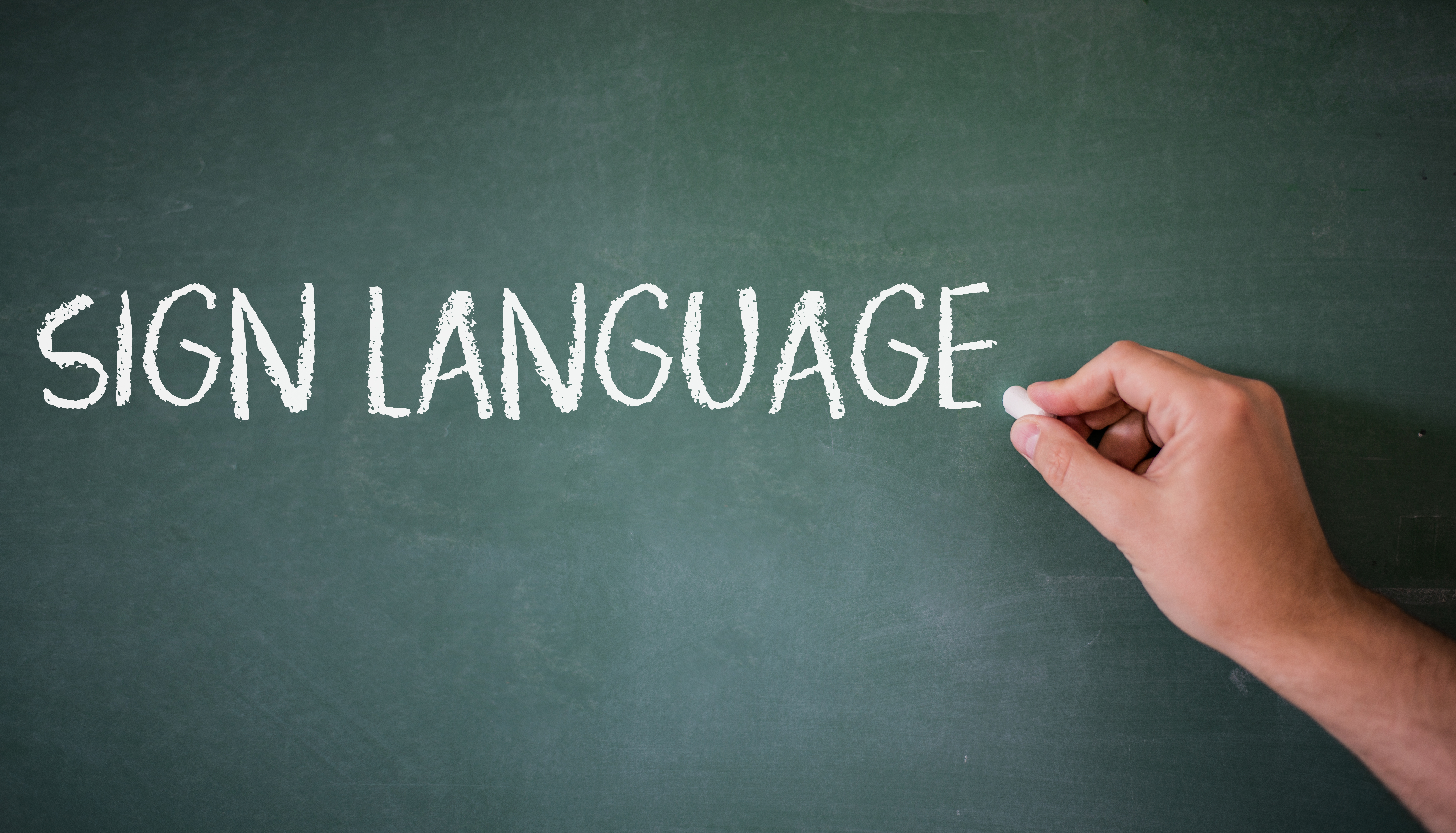 The words "Sign Language" written on a chalk board