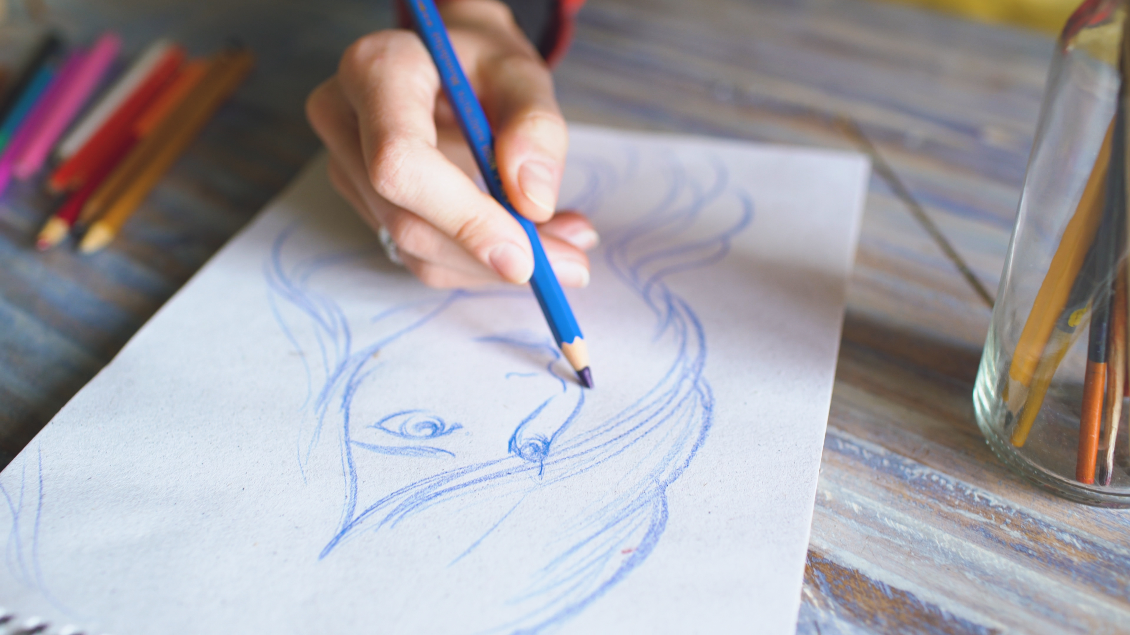 Person sketching a figure in blue