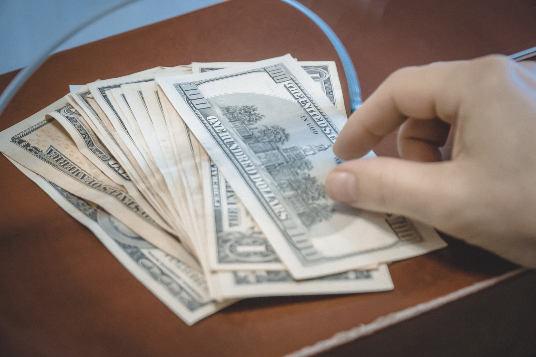 Person handing money to bank teller