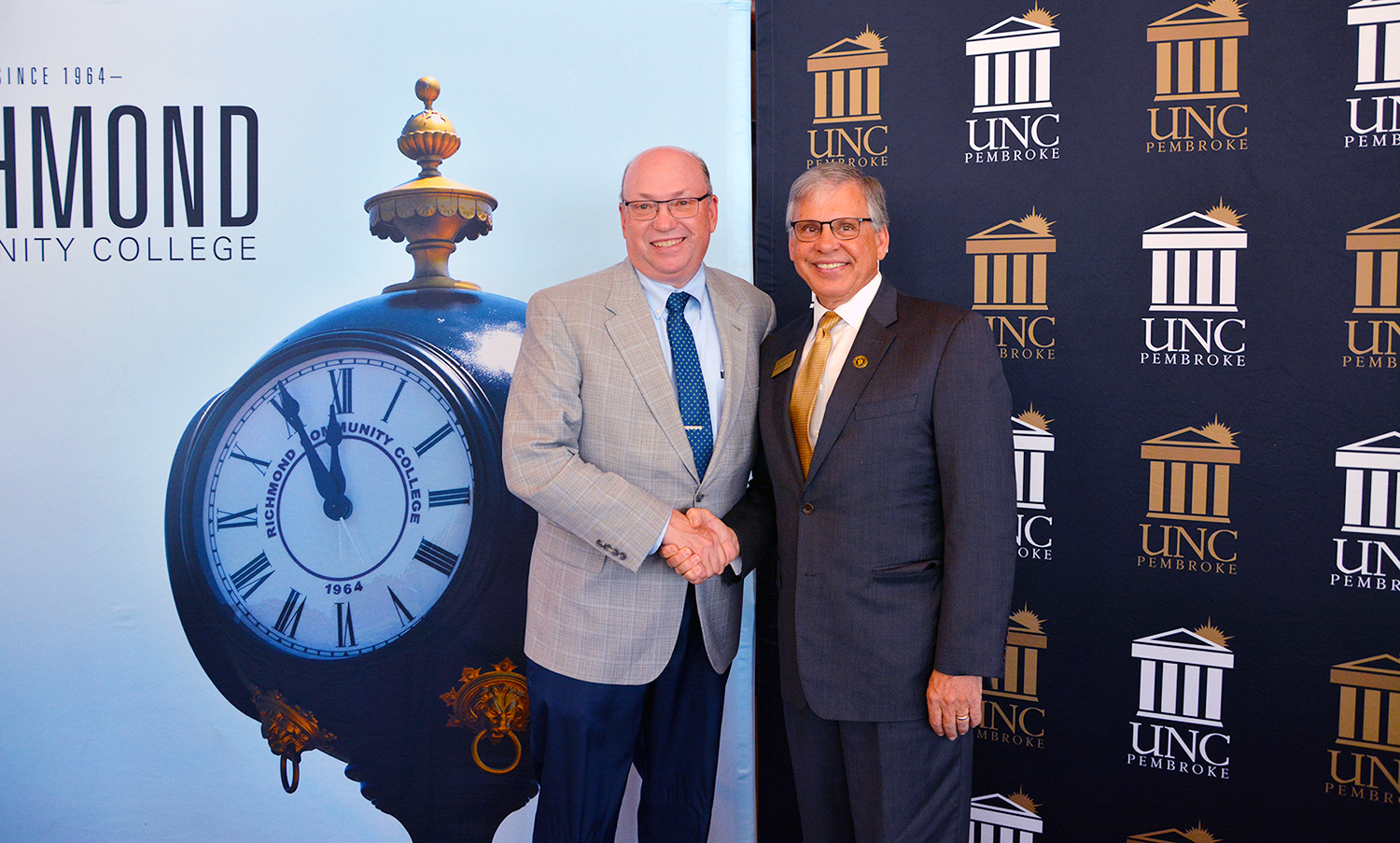 Dr. Dale McInnis, president of Richmond Community College, and Dr. Robin Cummings, chancellor of The University of North Carolina at Pembroke, shake hands 