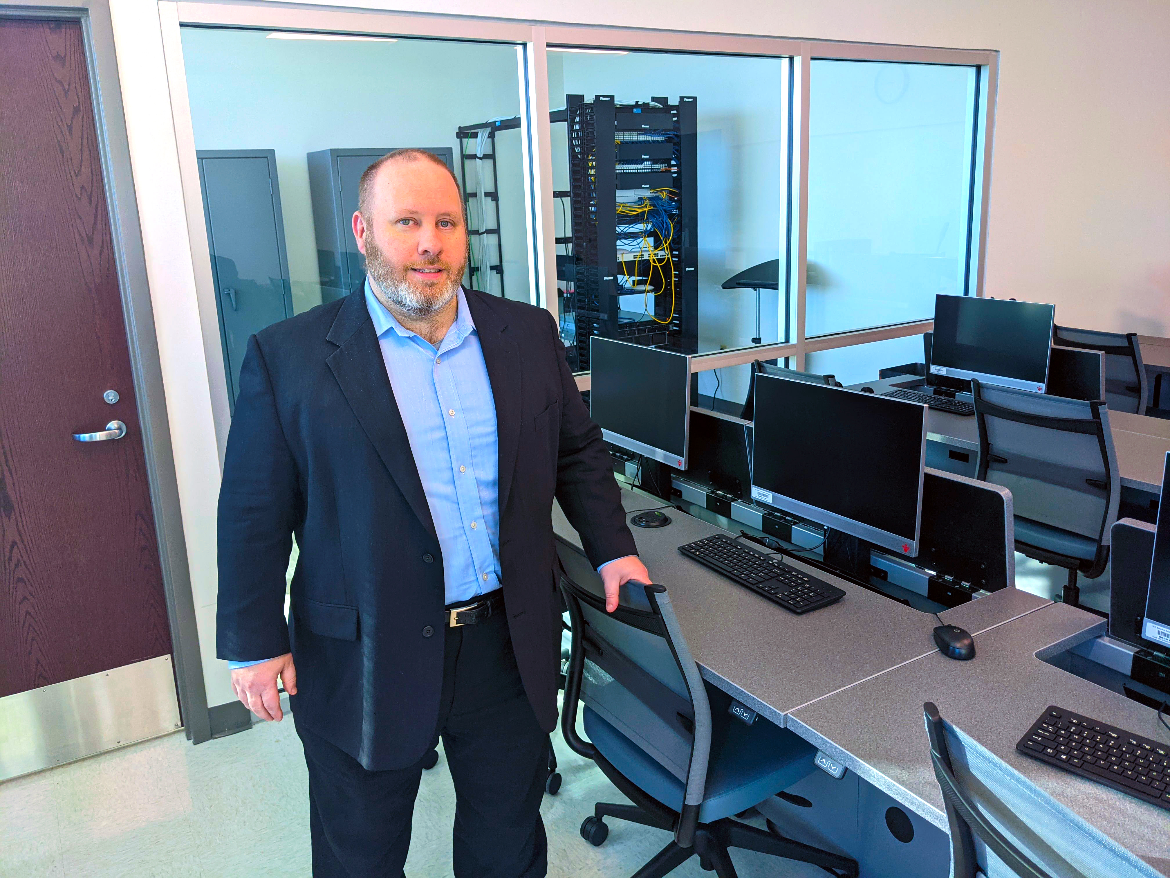 Brian Goodman stands in cyber security classroom