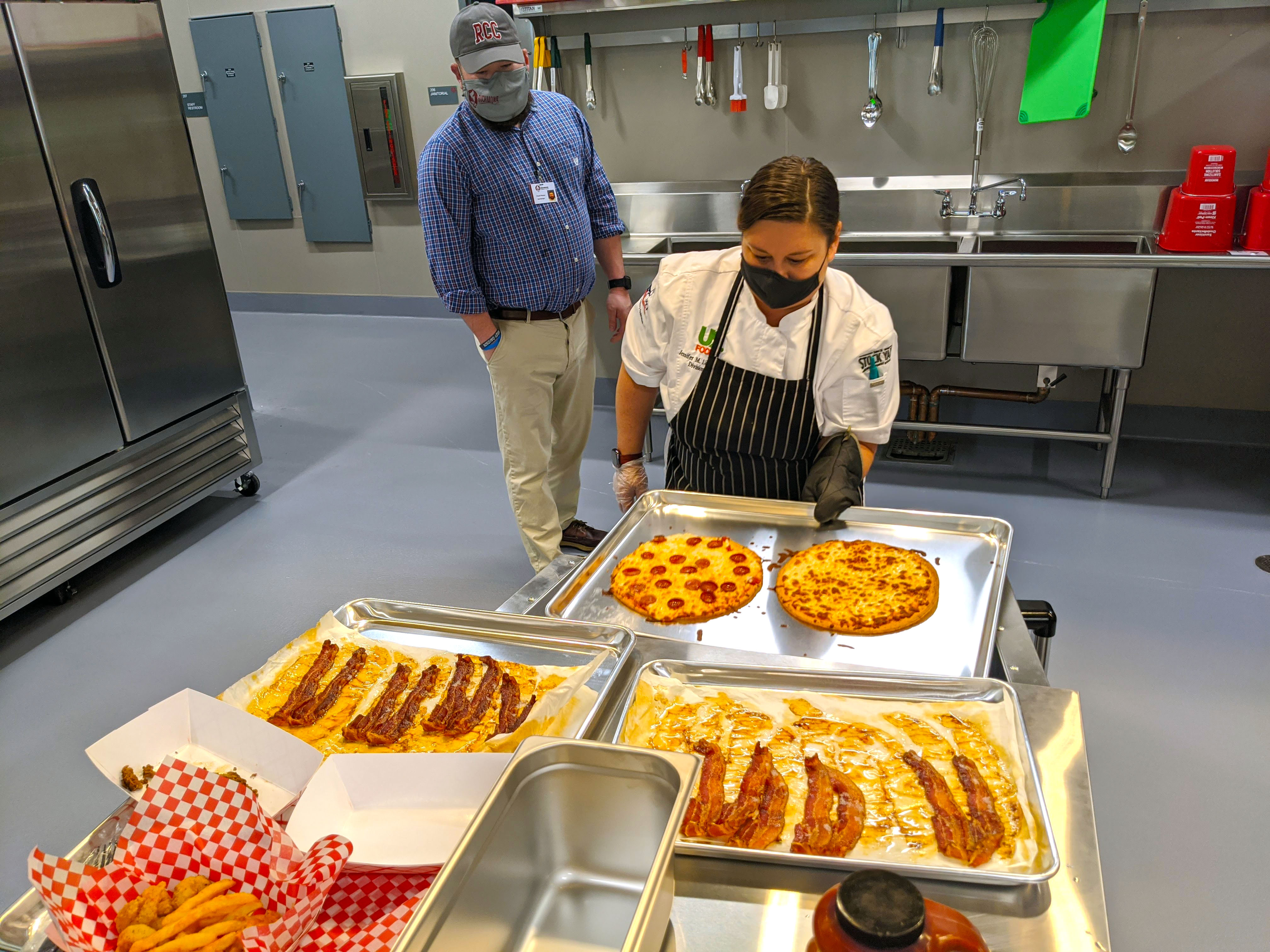 Chef pulls pizzas out of oven