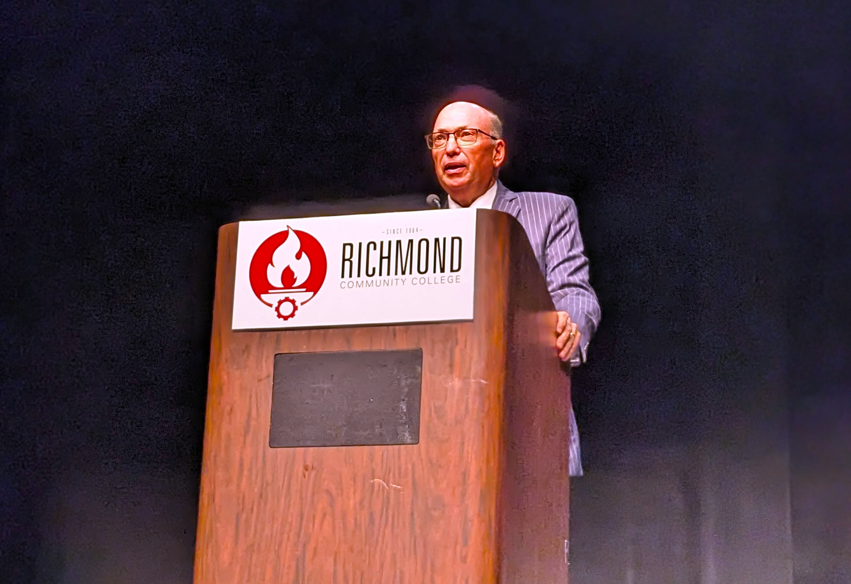 Dr. McInnis stands at the podium on the stage of the Cole.