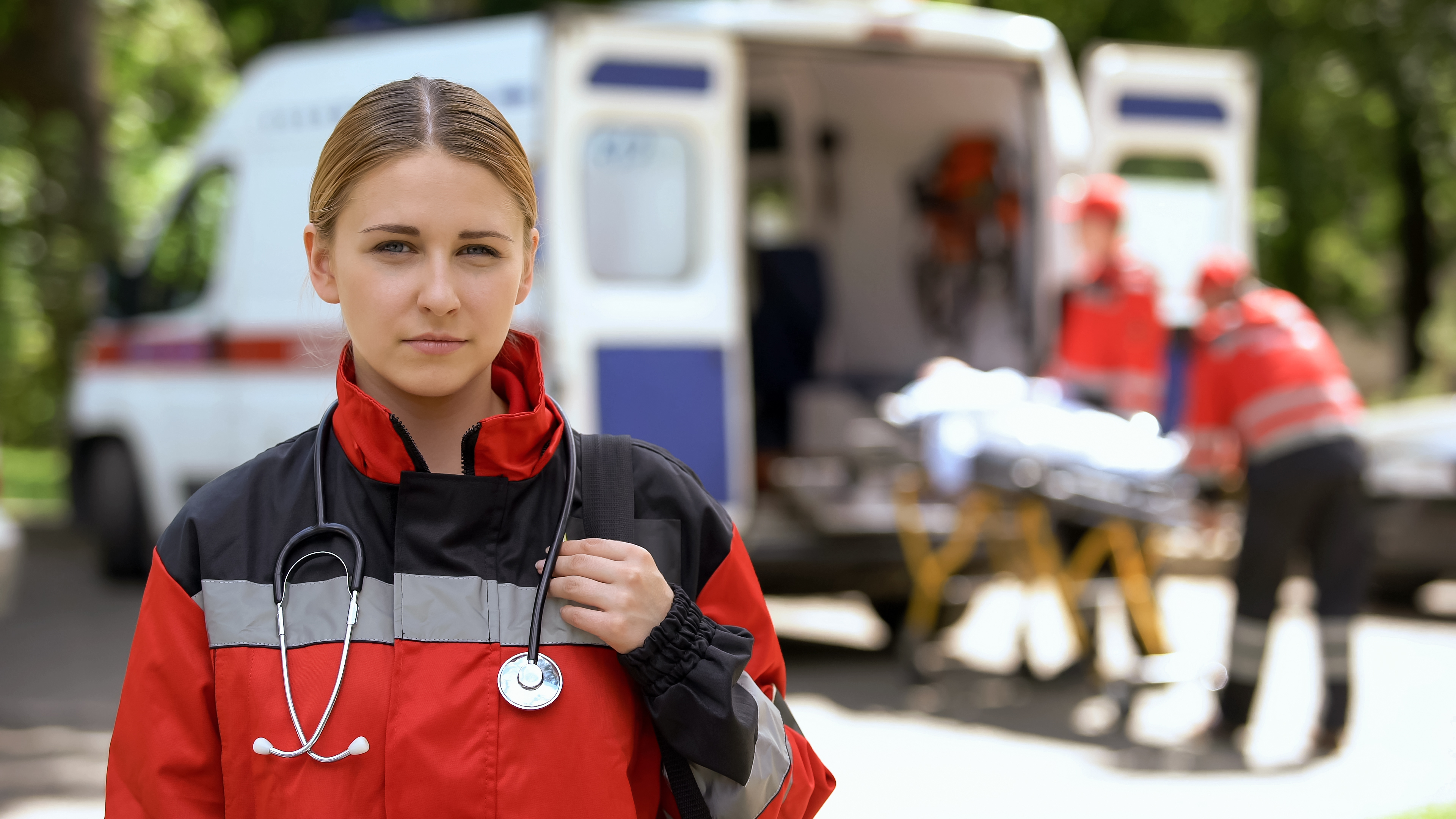 Female paramedic with ambulance in background