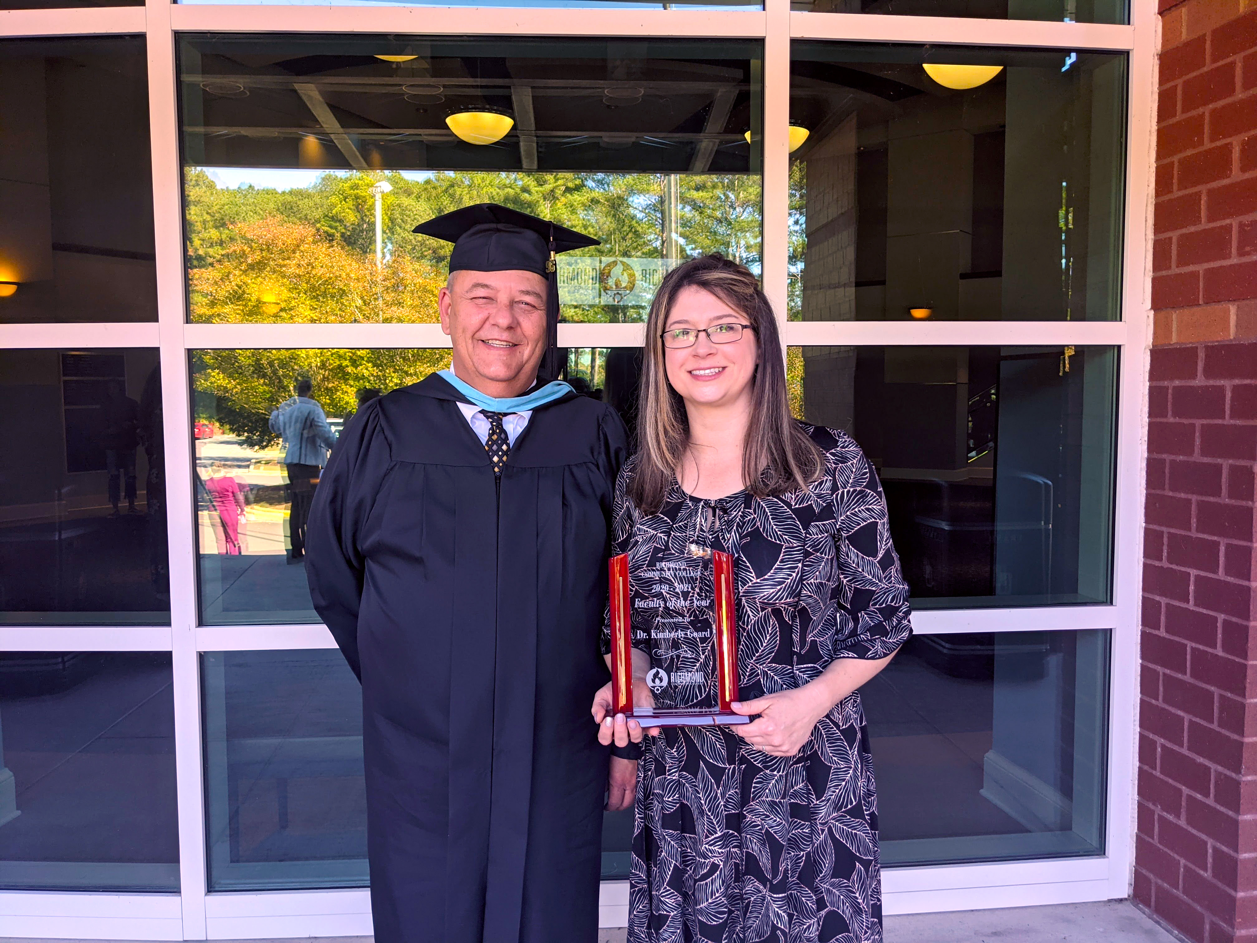 Kimberly Goard holds Faculty of the Year award with Vice President