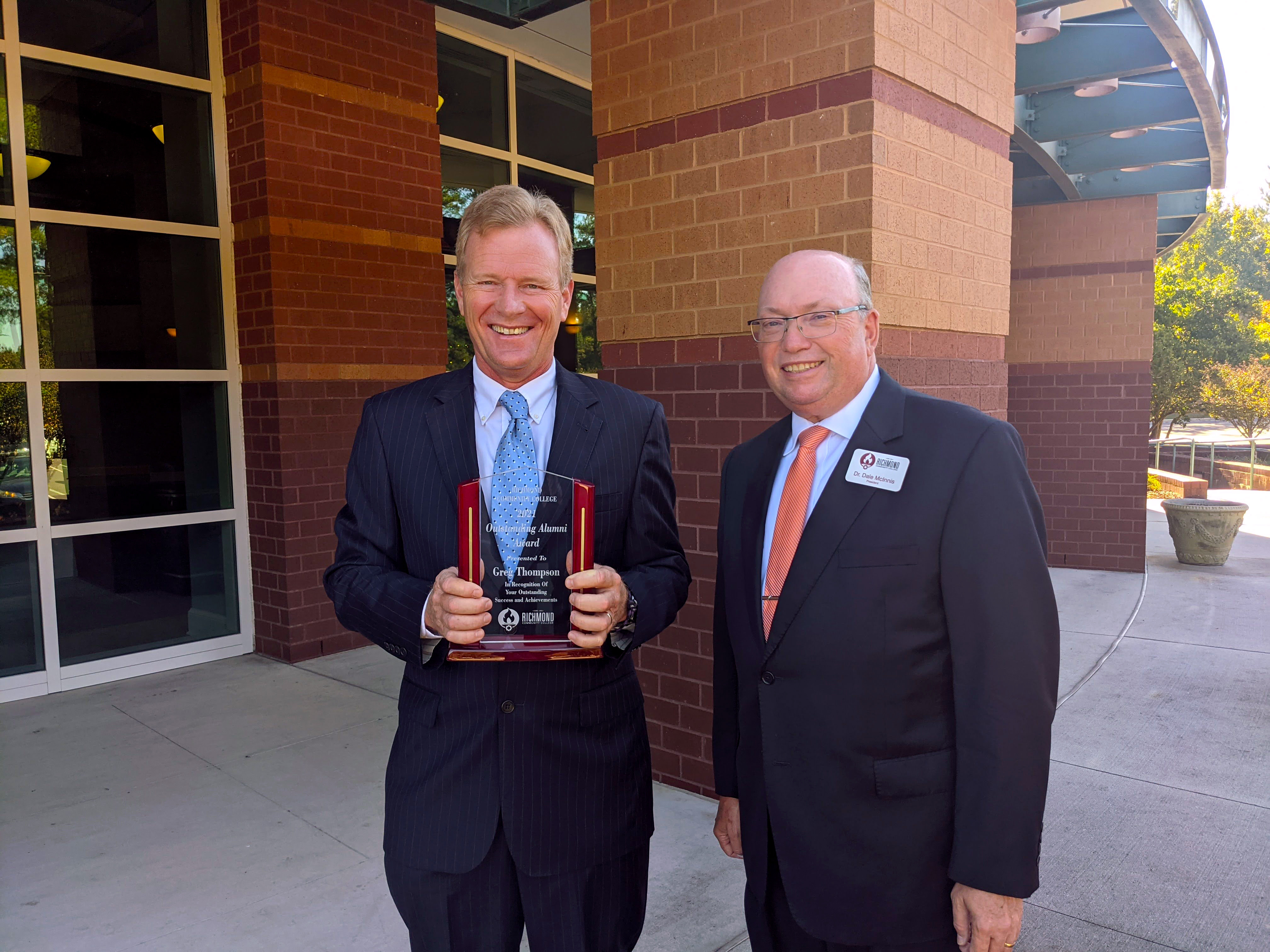 Greg Thompson holds award while standing with RCC president