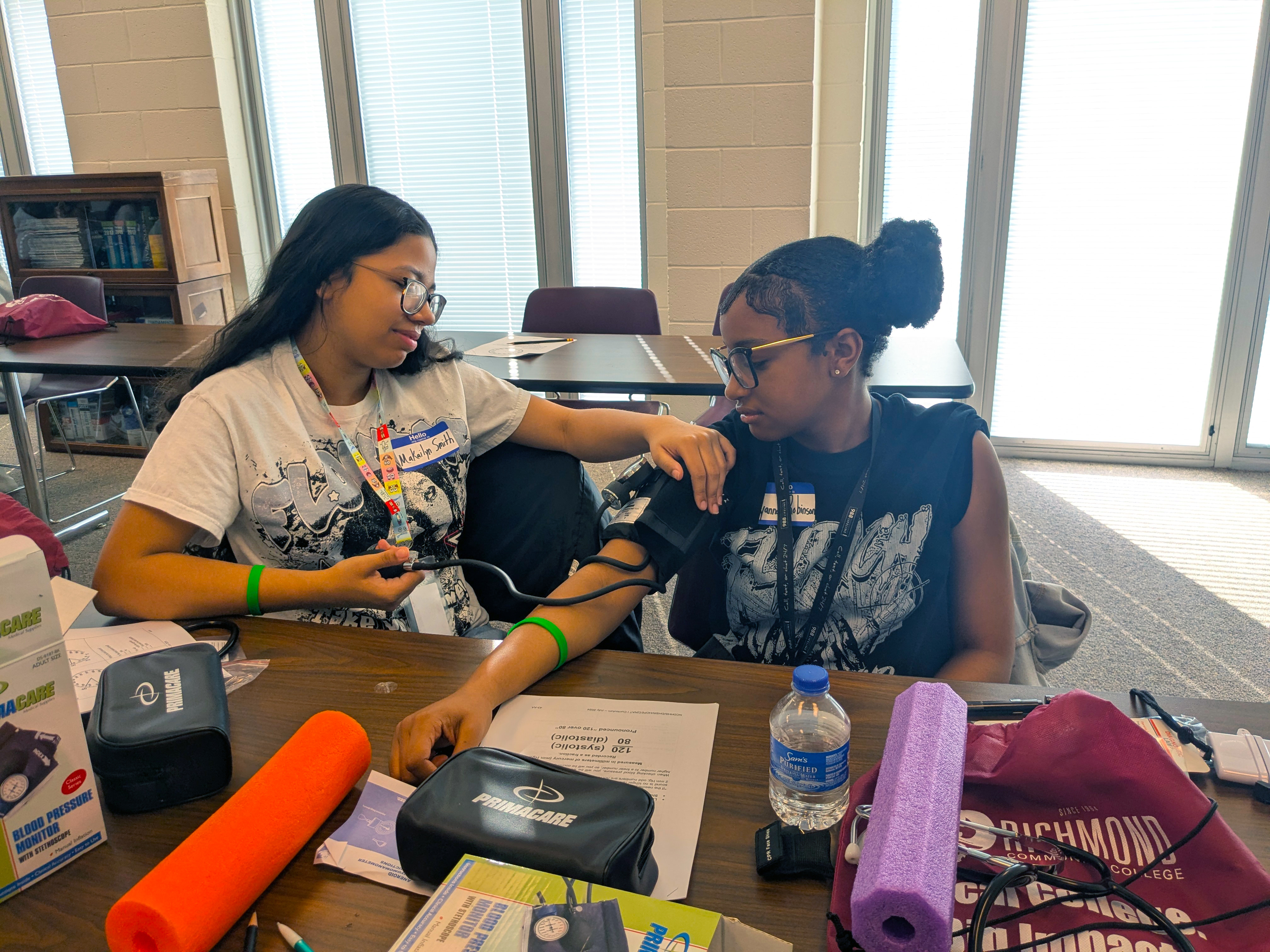Two students check each other's blood pressure.