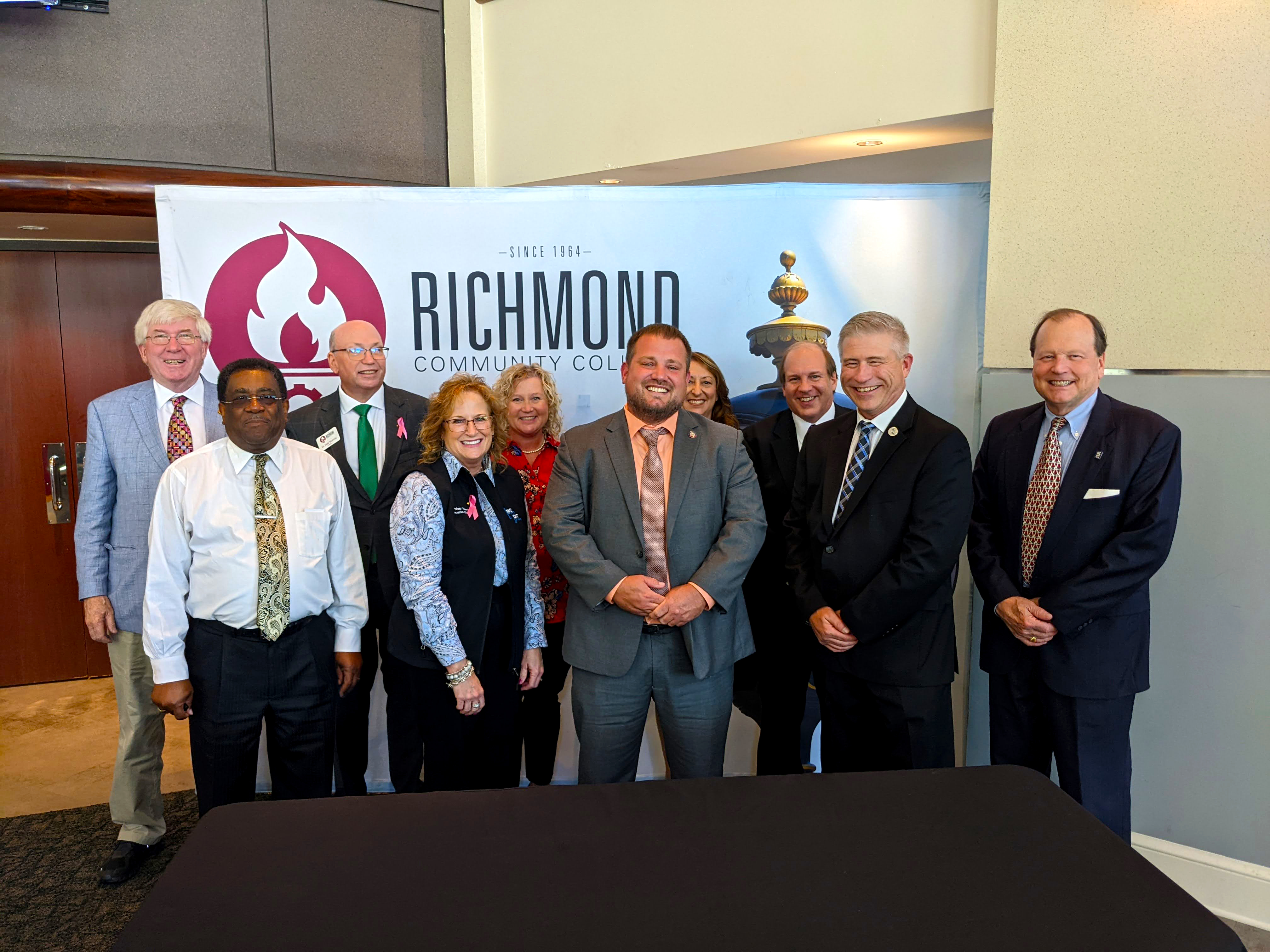 Group of leaders stand in front of RichmondCC Banner