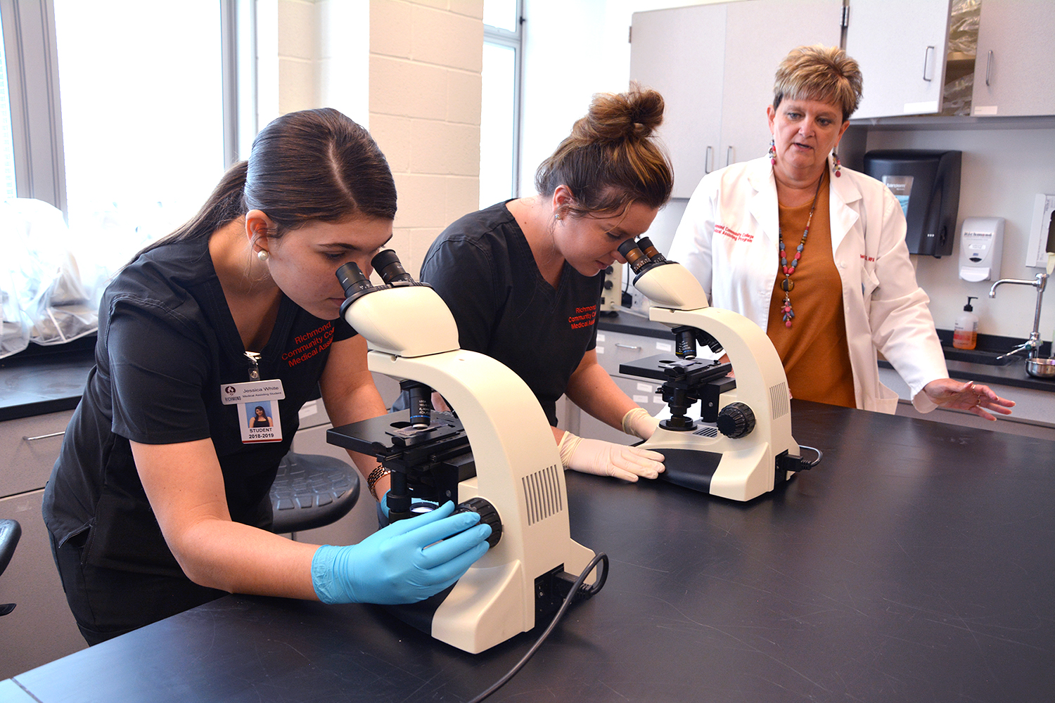 Medical Assisting students look in microscopes