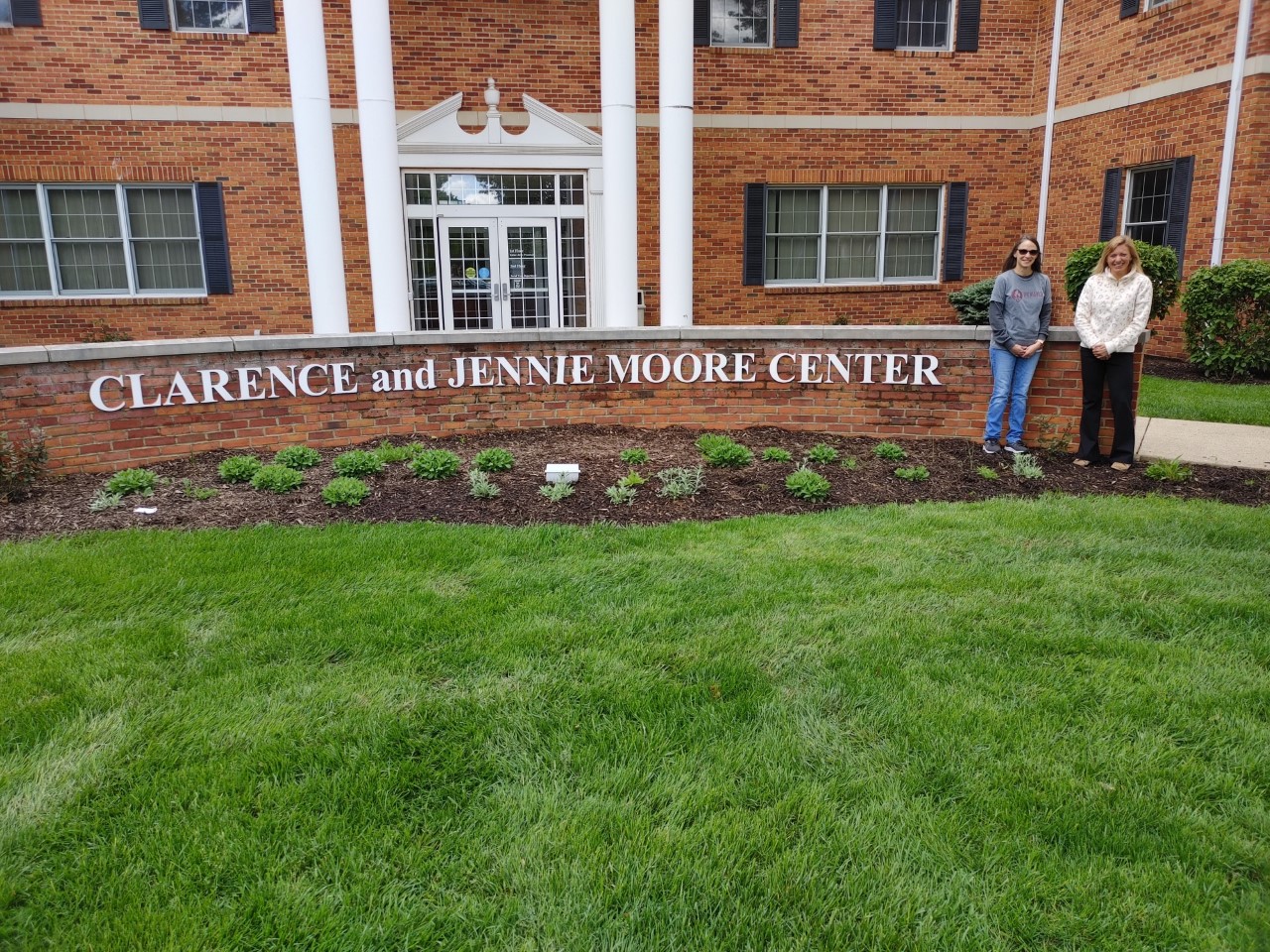 Two ladies standing in front of the Clarence and Jennie Moore Center