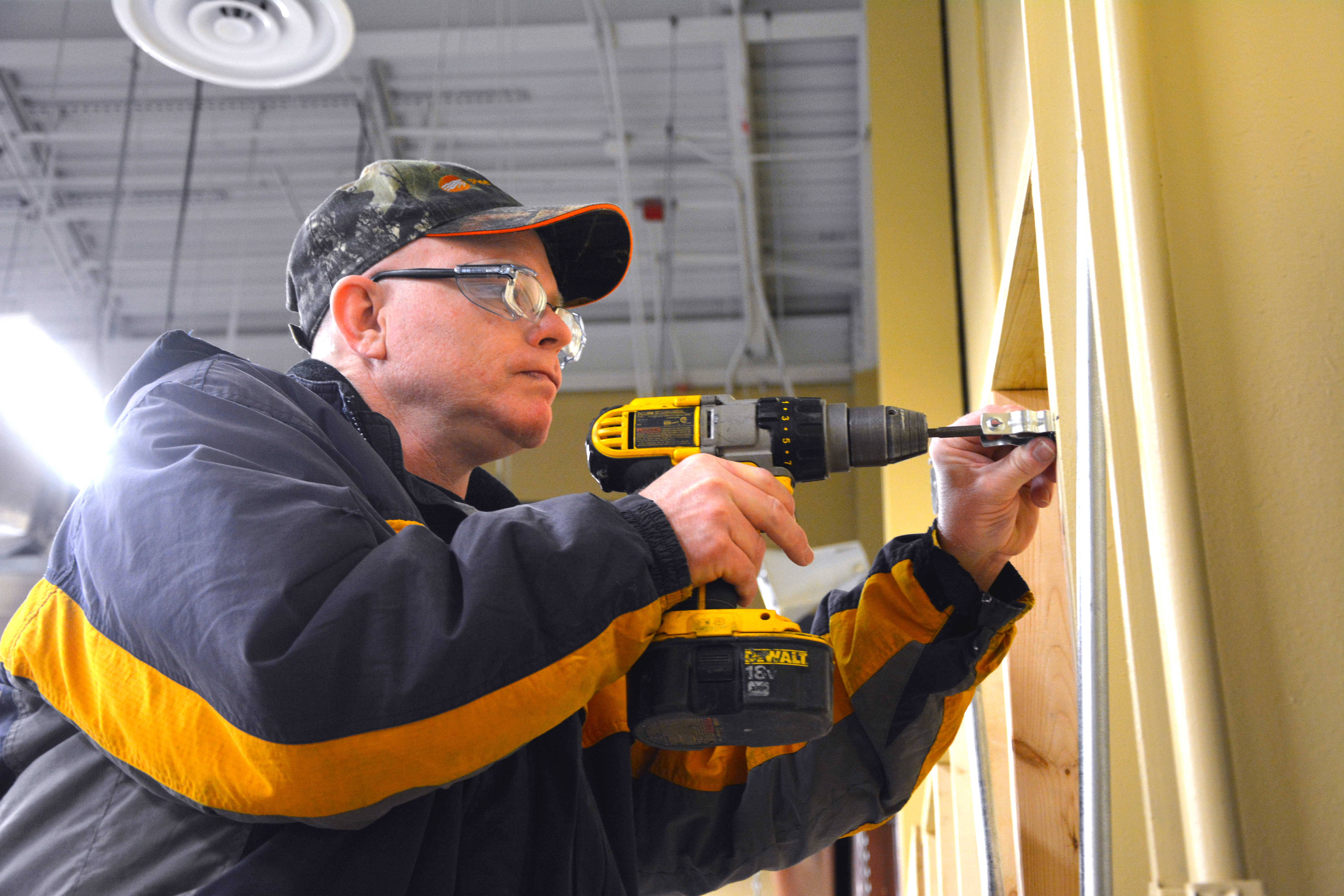 A man drills a hole in a wall