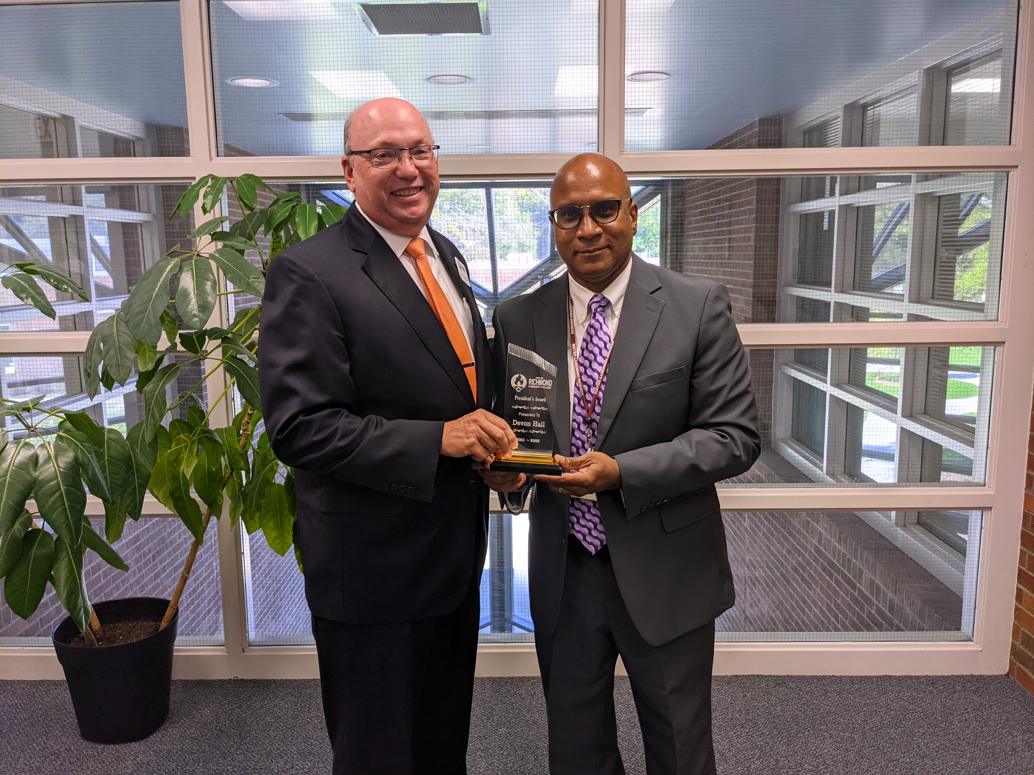 Dr. Devon Hall holds award with RCC President