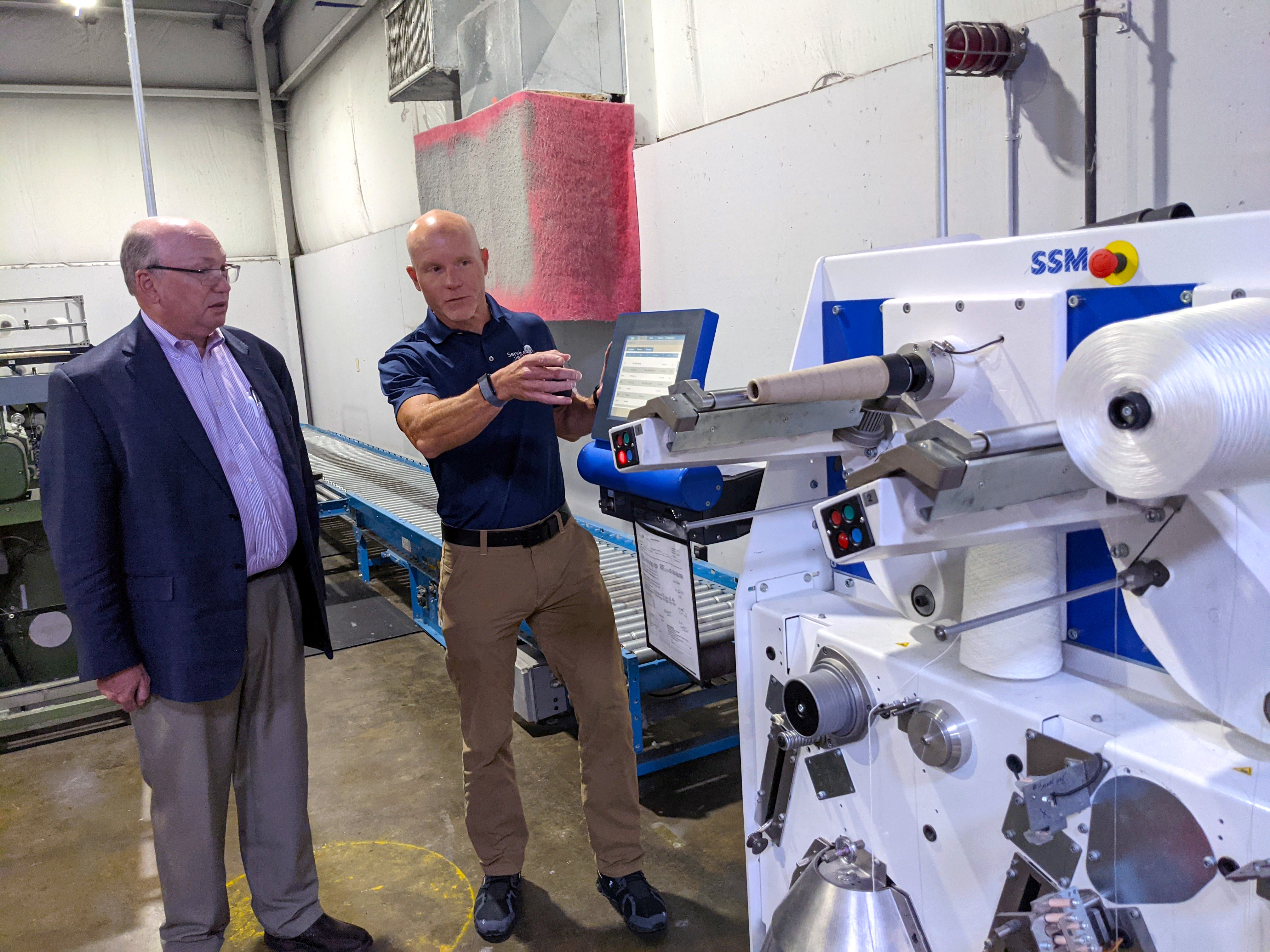 Service Thread and College leaders examine a new textile machine.