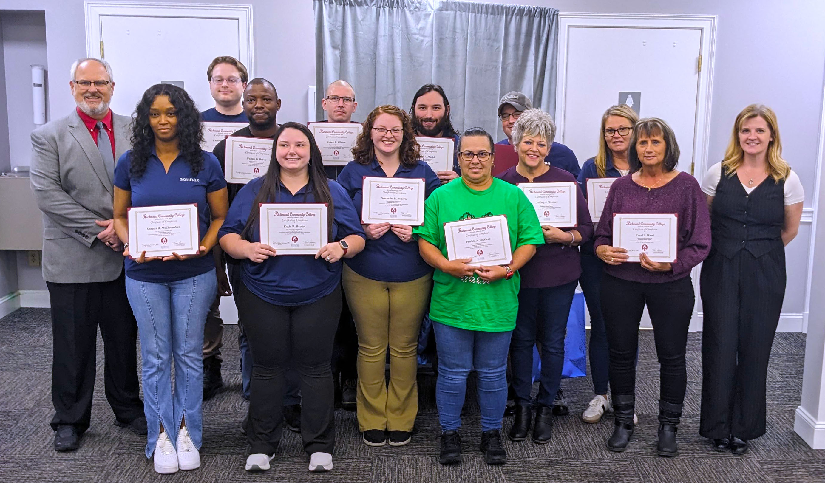 Sonnax employees hold their certificates of completion.