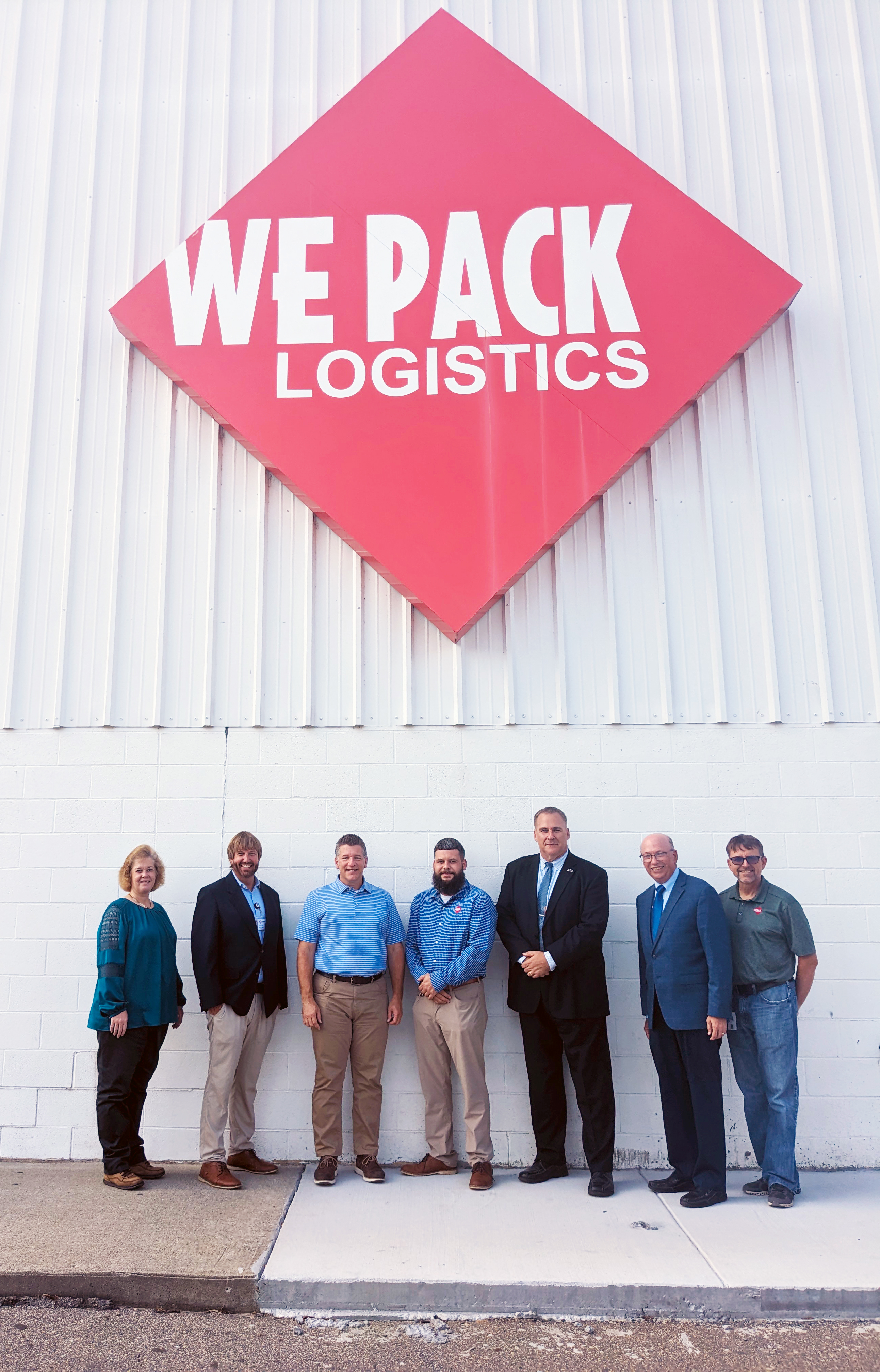 Group stands by We Pack Logistics sign