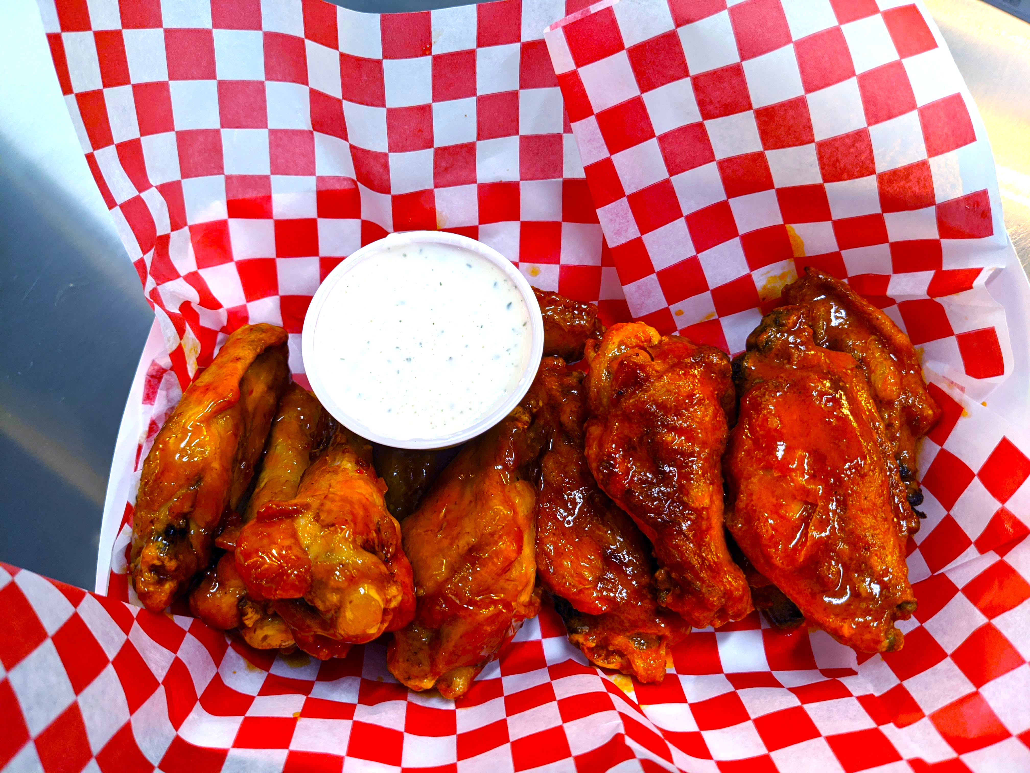 a basket of chicken wings with ranch dipping sauce
