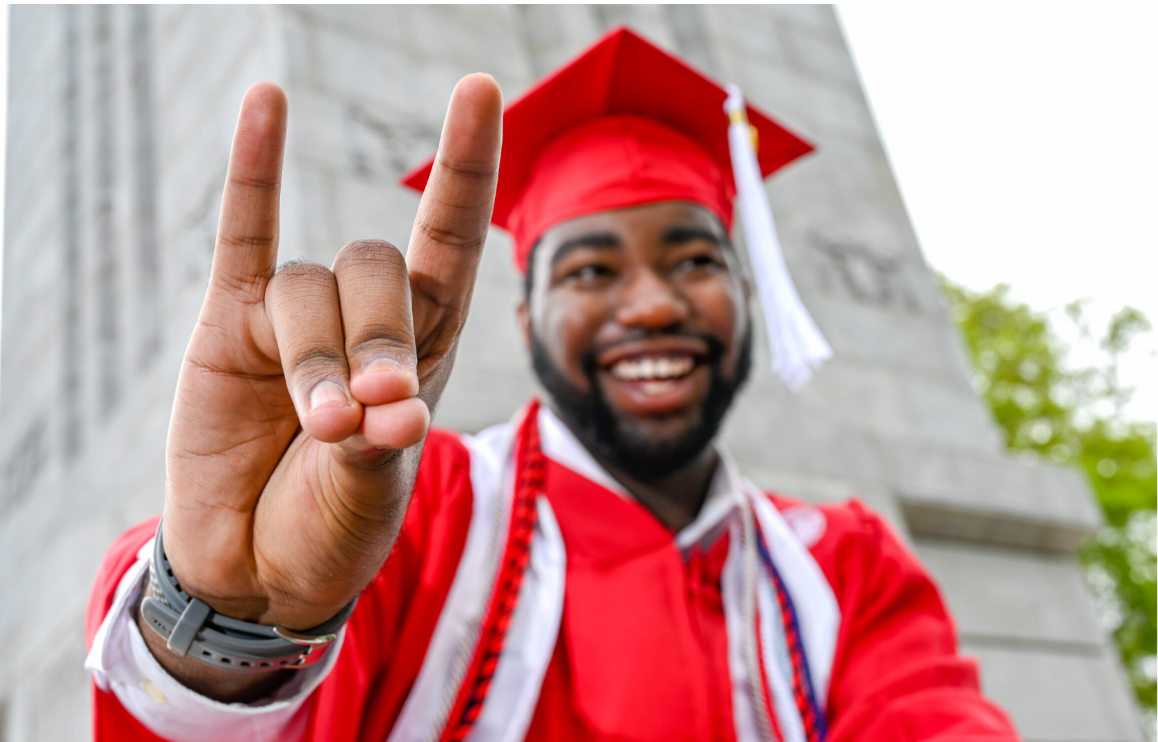 An NC State student does the sign for Wolfpack with his fingers.