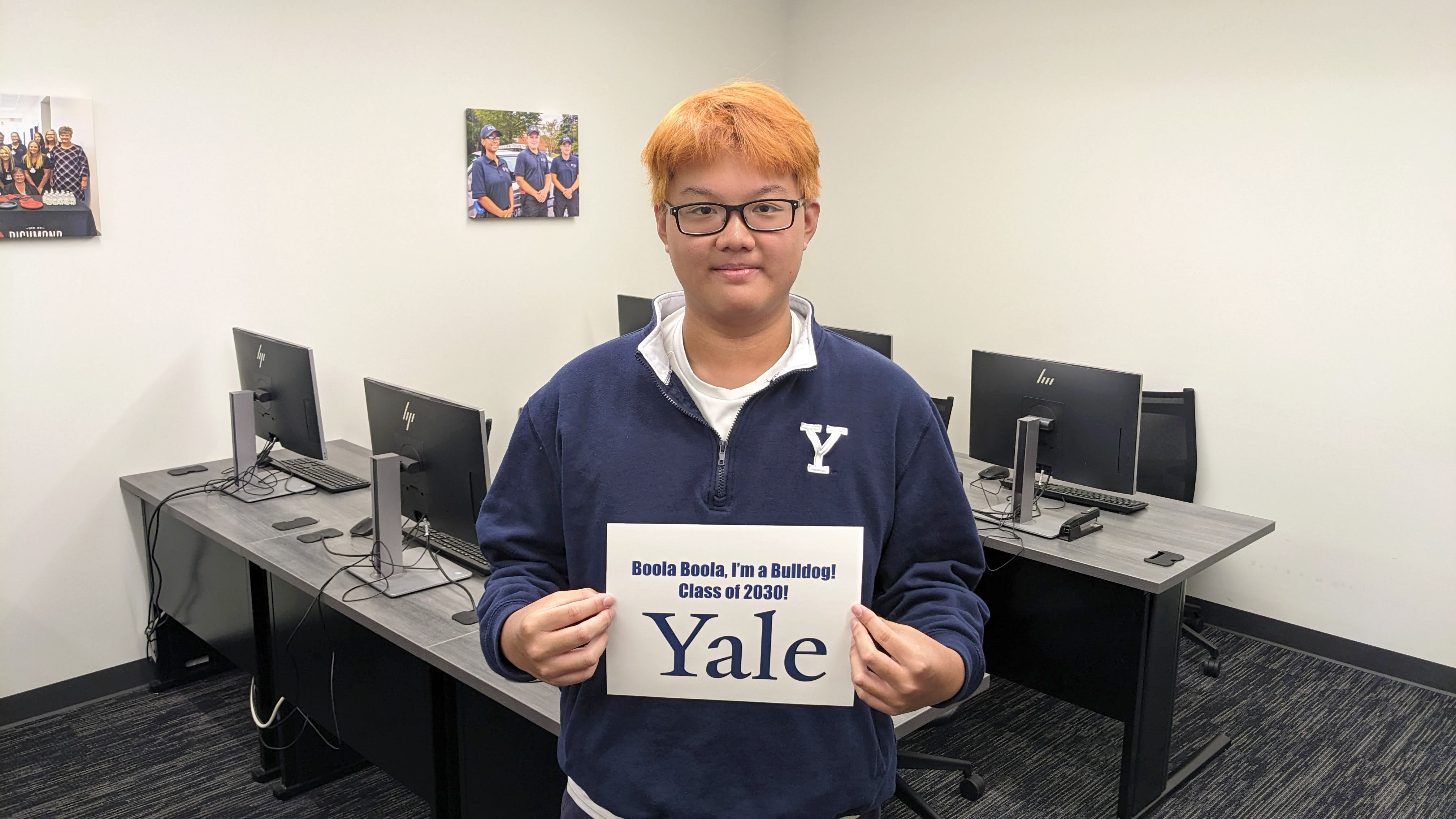 Andrew He holds up a sign that says Yale