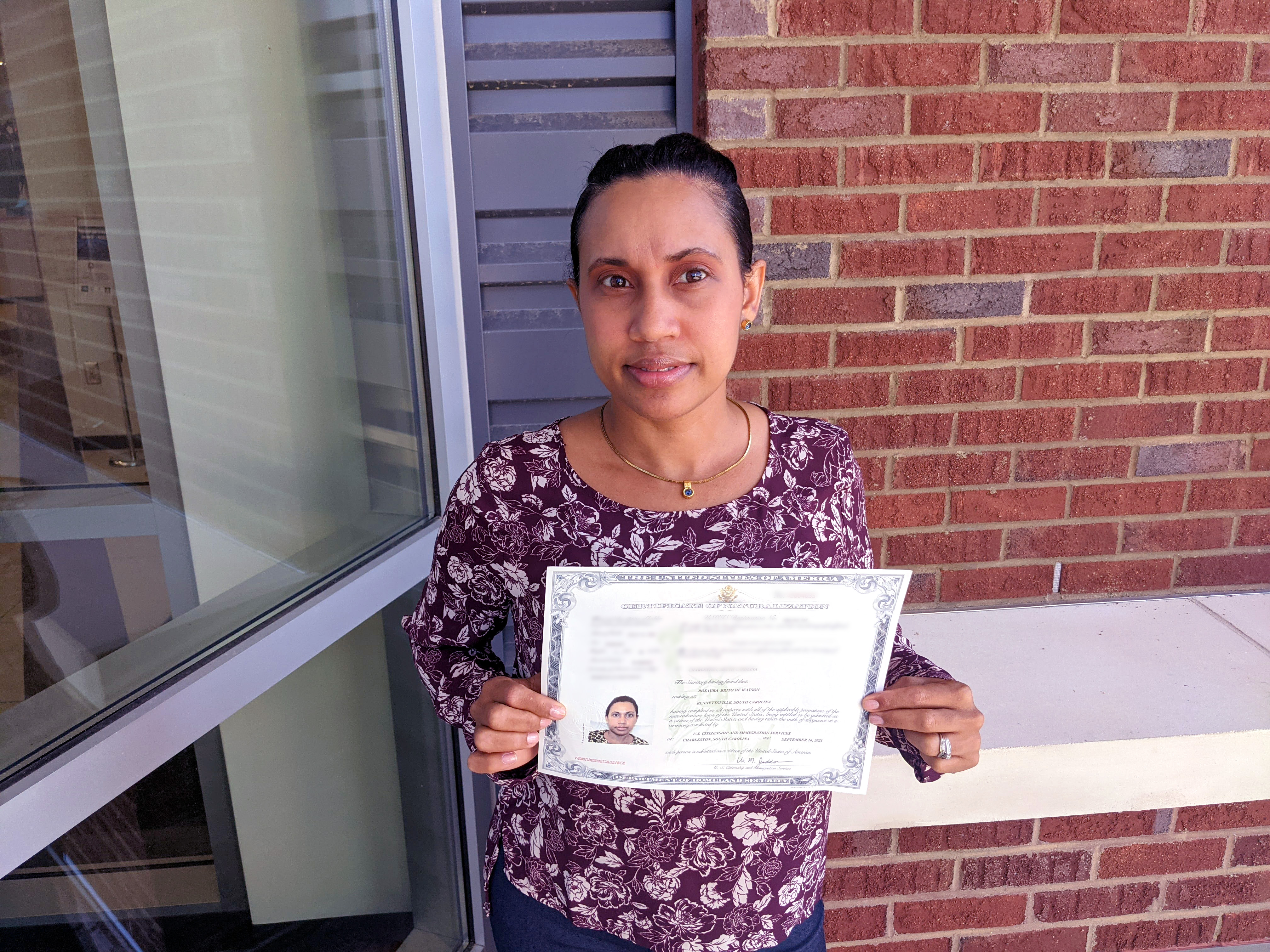 Rosauro De Watson holds her certificate that shows she is a legal US Citizen.