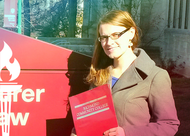 Sarah Doty holding a law book in front of her law school