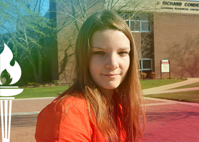 Saundra Honeycutt shown with a gradient over photo and white torch icon at left border of photo