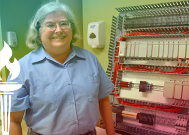 Shirley Koch standing by an electric panel she wired