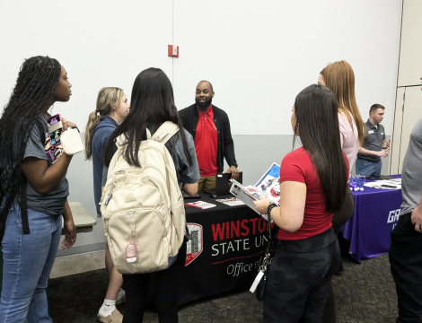 Photo of students speaking with an admissions representative at the cole auditorium 