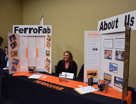 A representative from FerroFab sits a table with materials to distribute