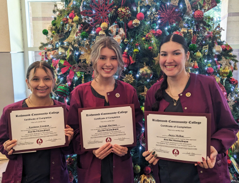 CNA graduates holding their certificates