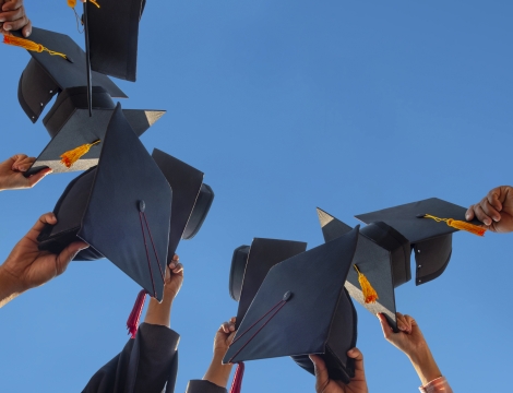 Graduation caps held up in the sky