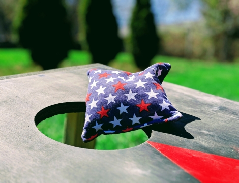 image of a starry cornhole bag resting atop a cornhole board outdoors