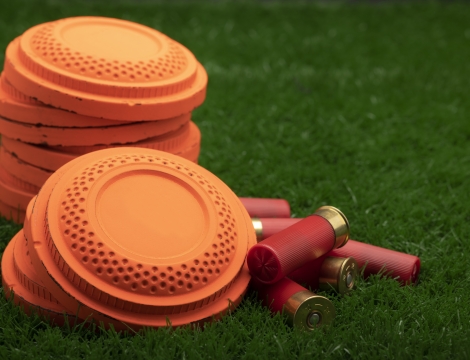 photo of clay pigeons and shotgun shells on grass