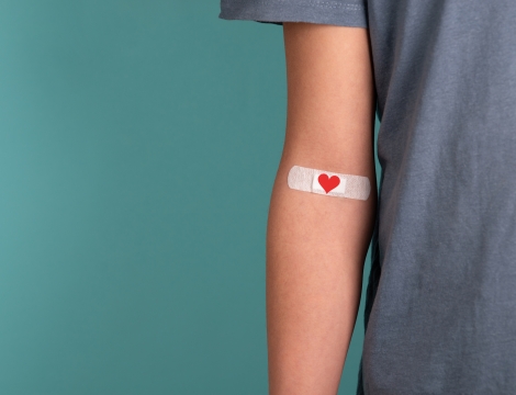 Photo of blood donor with heart-themed bandaid on their arm