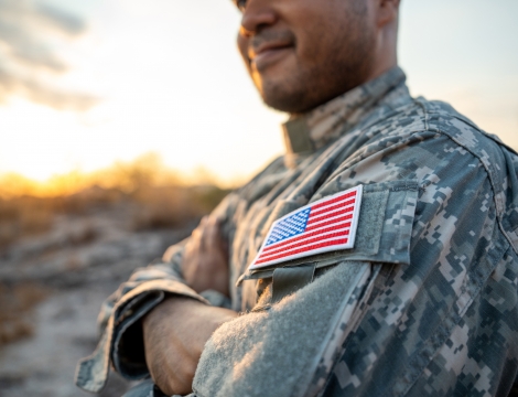 Photo of a military soldier with an american flag patch on his shoulder