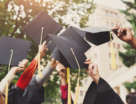 Graduation Caps being tossed in the air by students