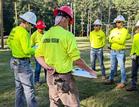 A photo of the previous class of lineman students working in the lineman yard