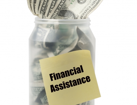 Jar of Money with sticky note saying Financial Assistance