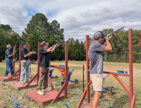 Participants of the clay shooting targets aiming at clay pigeon