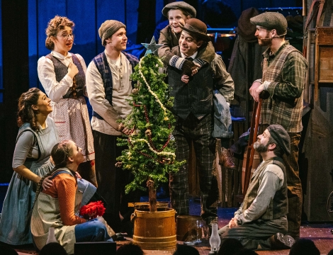 Theater performers around a Christmas Tree on Stage