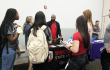 Photo of students speaking with an admissions representative at the cole auditorium 