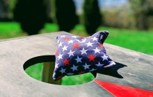 image of a starry cornhole bag resting atop a cornhole board outdoors