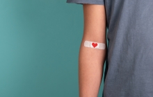 Photo of blood donor with heart-themed bandaid on their arm