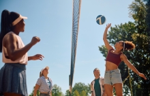 Photo of a volley ball player hitting a ball over the net