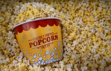 Photo of bucket of popcorn laying in a large amount of popcorn