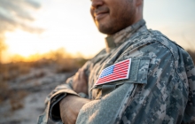 Photo of a military soldier with an american flag patch on his shoulder